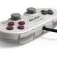 A retro-styled grey controller with purple face buttons and dual analogue sticks, inspired by classic 8-bit handheld aesthetics