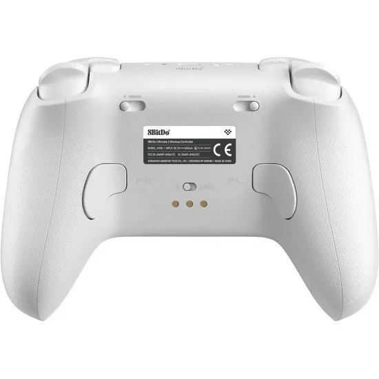 A sleek white pro-style controller with offset sticks and back paddles sitting in a matching white magnetic charging dock