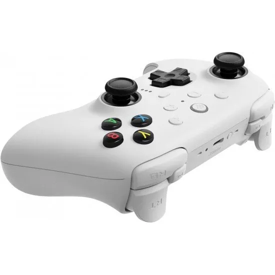 A sleek white pro-style controller with offset sticks and back paddles sitting in a matching white magnetic charging dock