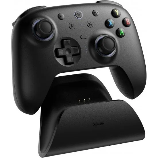 A sleek wireless gaming controller sitting on its dedicated charging dock with visible back paddles and textured grips