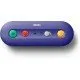 A small purple wireless adapter with ports for GameCube and Wii Classic controllers next to a Nintendo Switch console