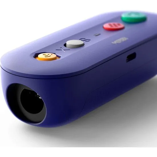 A small purple wireless adapter with ports for GameCube and Wii Classic controllers next to a Nintendo Switch console