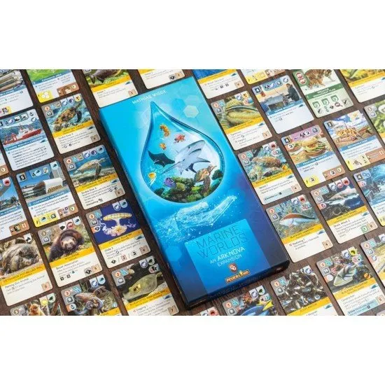 A board game expansion box showing a large aquarium tank with various colourful fish and marine life inside a modern zoo setting