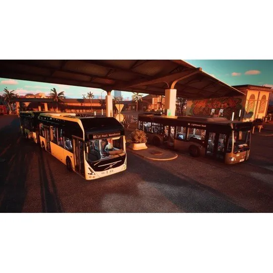 A modern licensed coach bus driving along a scenic coastal road in a southern European city with several other buses in the background