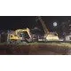 A high-power yellow excavator working on a large-scale construction site with a sprawling city skyline in the distance