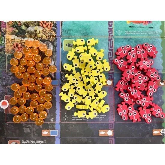 A collection of colourful, tactile 3D tokens representing fish eggs, small fry, and schools of fish