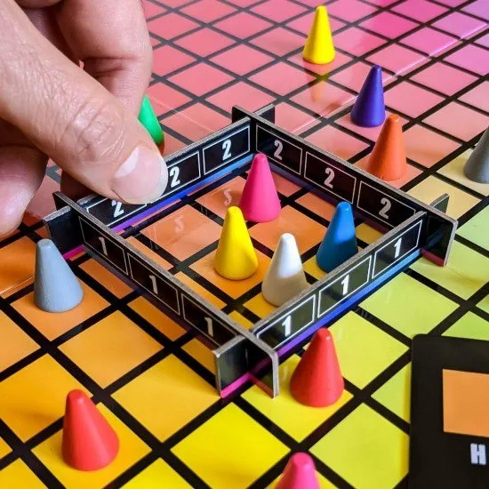 The box art for the Hues and Cues board game, featuring a colorful grid of hues with game pieces on it.