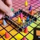 The box art for the Hues and Cues board game, featuring a colorful grid of hues with game pieces on it.