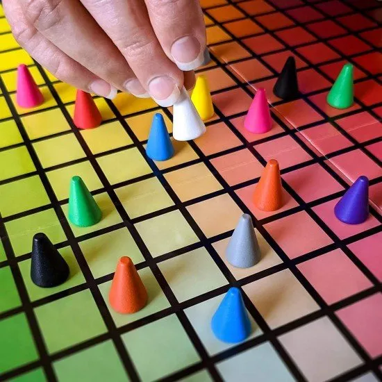 The box art for the Hues and Cues board game, featuring a colorful grid of hues with game pieces on it.