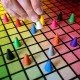 The box art for the Hues and Cues board game, featuring a colorful grid of hues with game pieces on it.