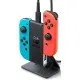 Official Nintendo Switch packaging showing a black two-way charging stand holding a blue and red Joy-Con controller with a power cable attached
