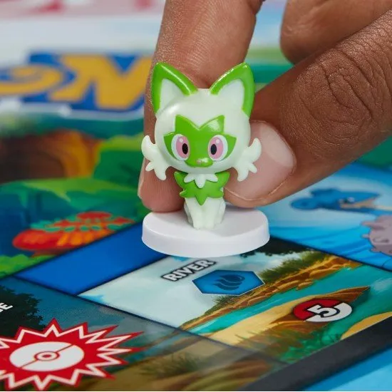 The box art for Monopoly - Pokémon Edition, showing a game board with Pokémon locations and the character tokens, including Pikachu.