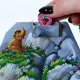 Paleolino cooperative children's board game featuring a 3D mountain, resource chips and prehistoric village building