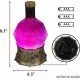A d20-shaped glass bottle containing glowing purple liquid with a swirling mist effect sitting on a grey stone castle base