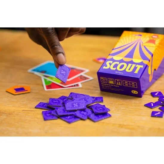 The box art for the Scout card game, showing a clown and circus performers with the game's title in a stylized font. The small, square box is visible.