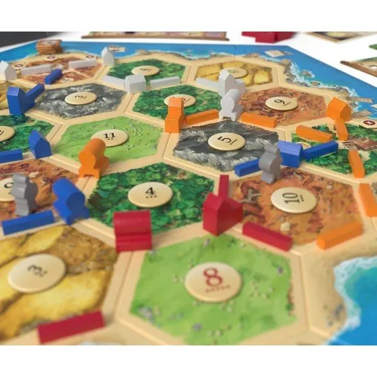 CATAN Traders & Barbarians 6th Edition box art showing new game components, merchant caravans, and barbarians threatening settlements